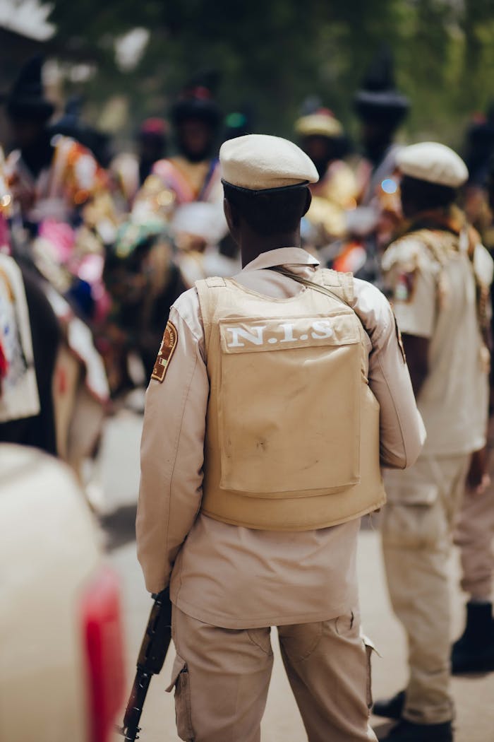 Nigerian police officer in uniform overseeing a cultural festival outdoors.